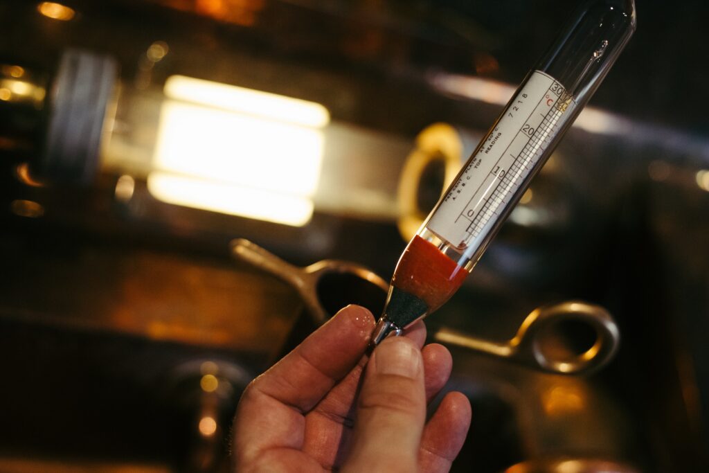Man's hand holding a hydrometer