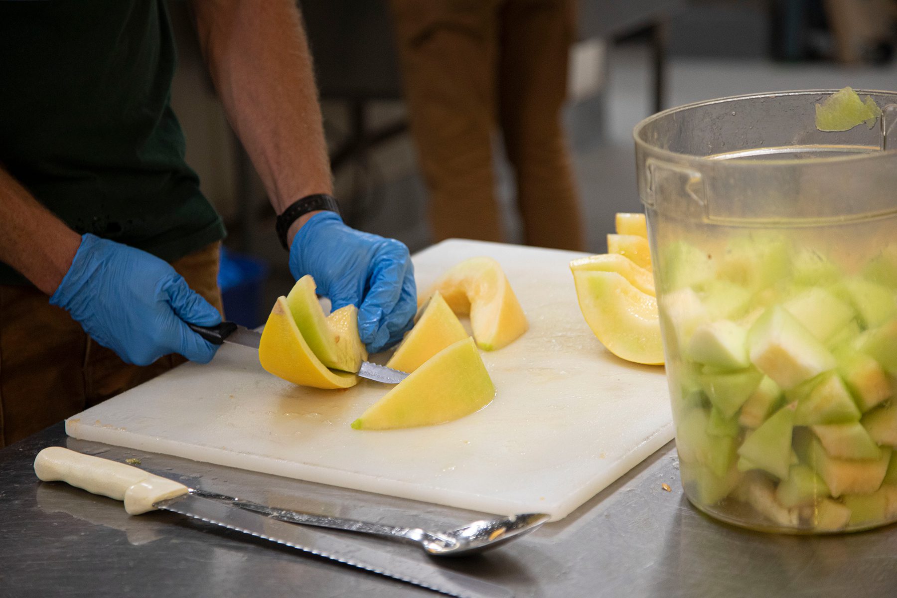 Chopping melons on a cutting board in a kitchen