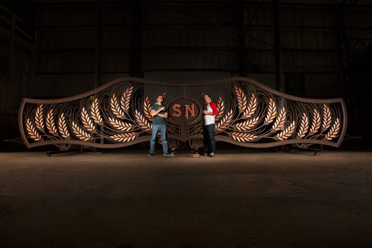 Owners of Ninkasi Brewing Company pose with custom fabricated entry gate