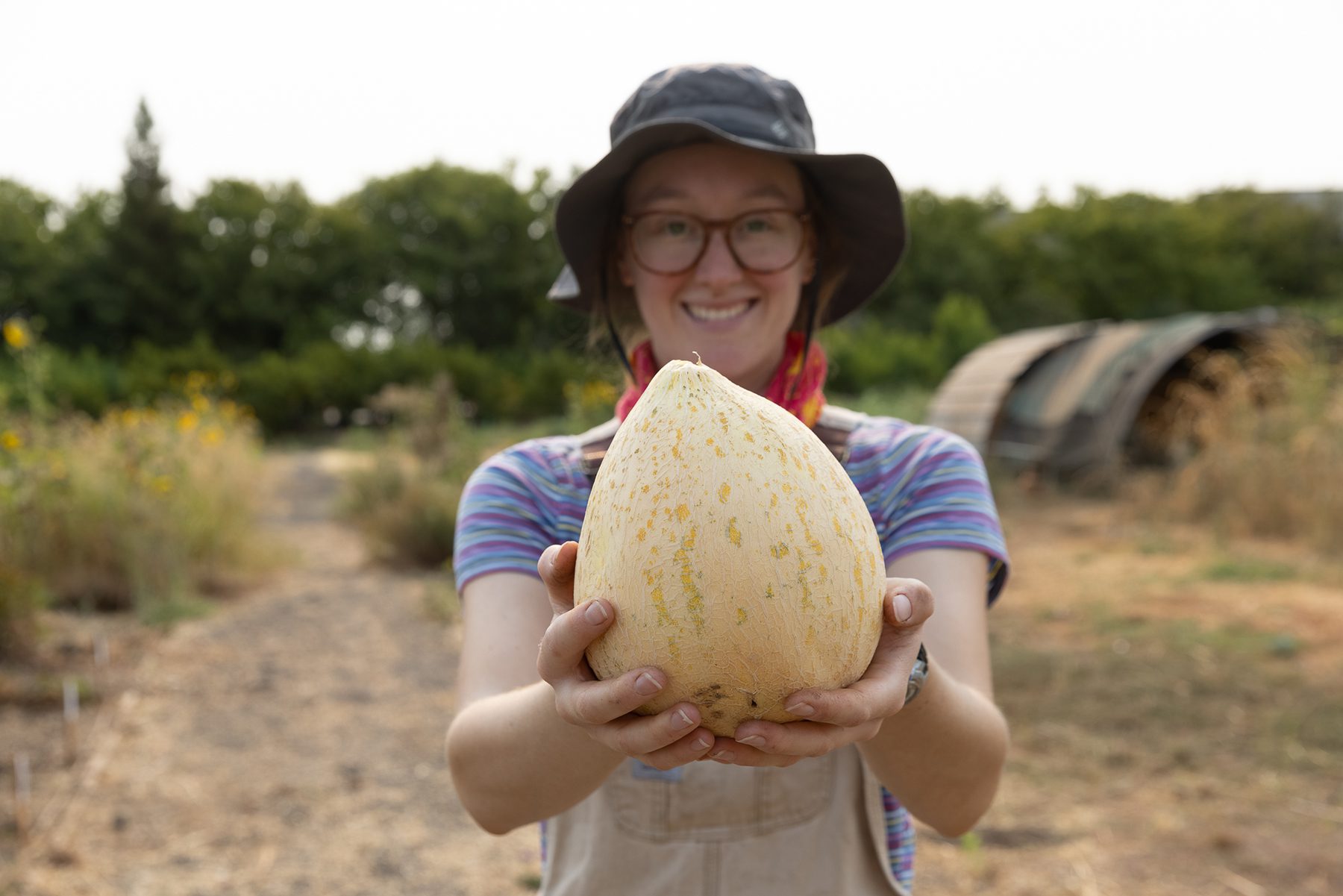 A Sierra Nevada employee holding out a melon harvested from the brewery garden