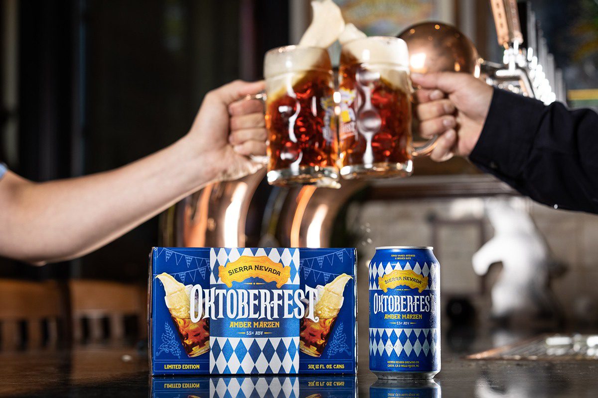 Two clinking steins of beer above a six-pack of Sierra Nevada Oktoberfest