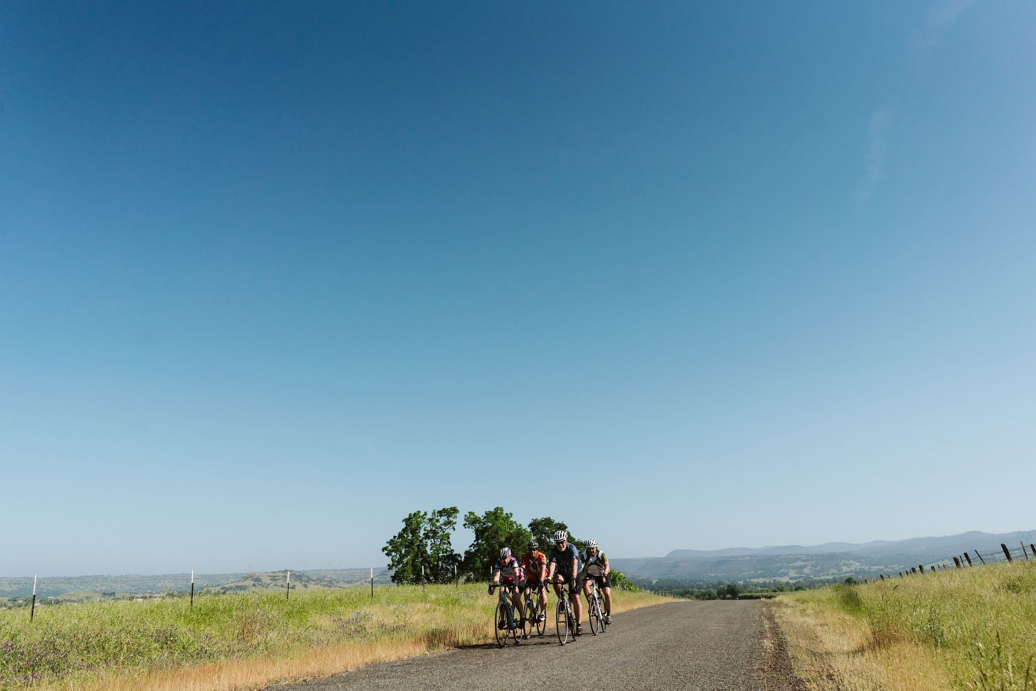 Group of cyclists riding with deep blue sky beyond