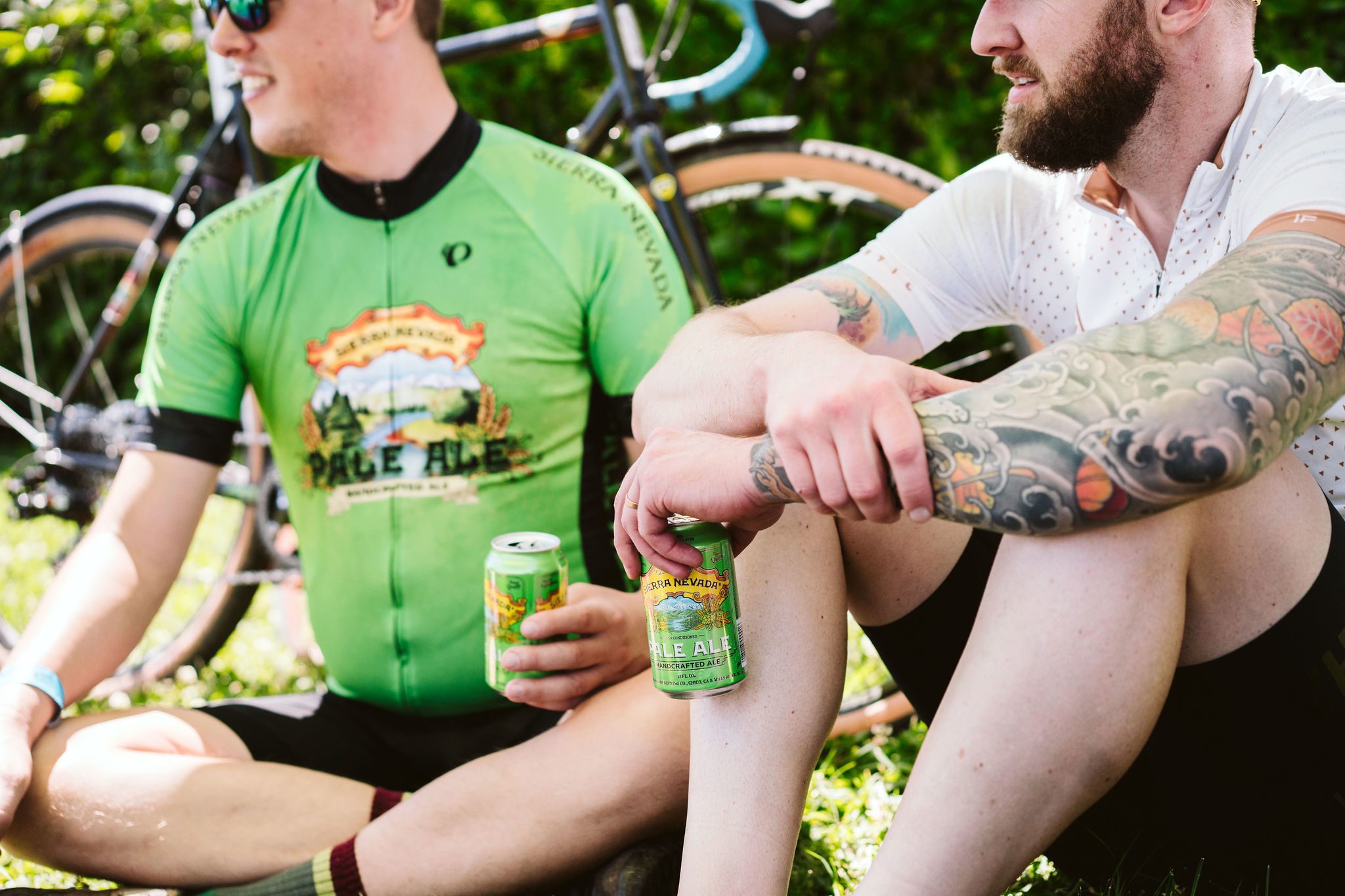 Two cyclists talking and holding Sierra Nevada beers