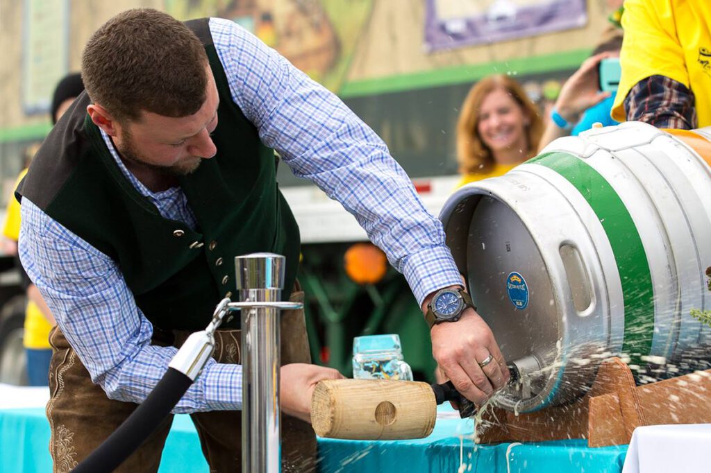 A Sierra Nevada brewer tapping a cask, or firkin, of beer during an Oktoberfest party