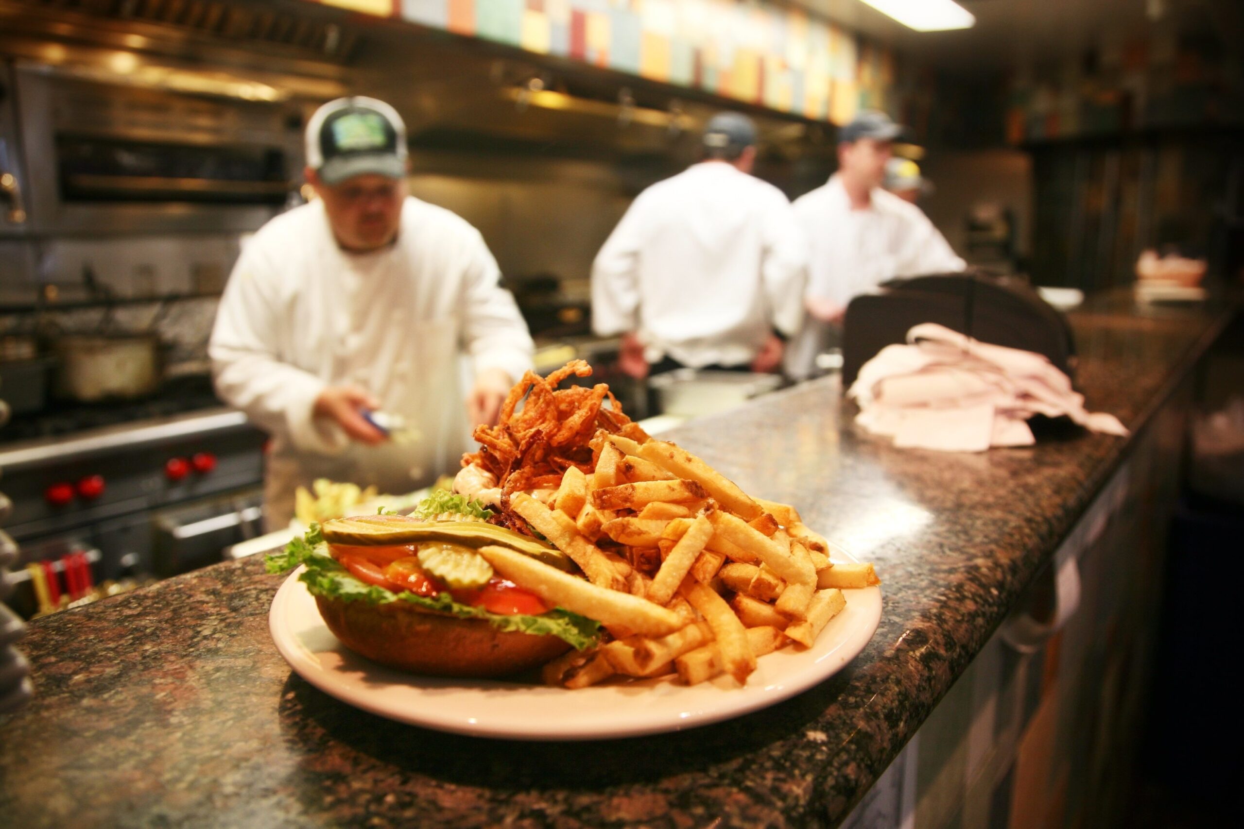 Plate of hamburger and fries in restaurant kitchen