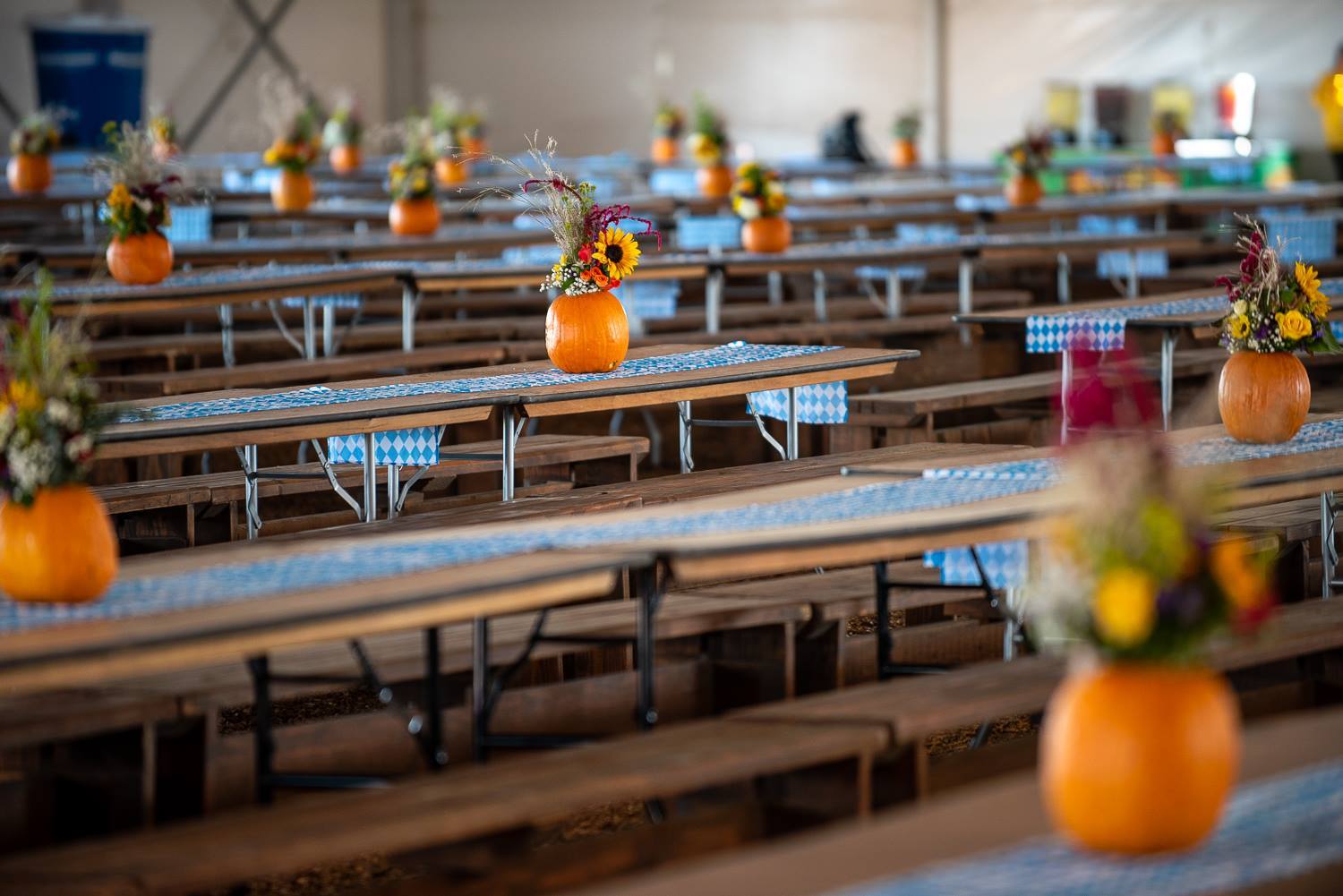 Tables topped with flower-filled pumpkin centerpieces
