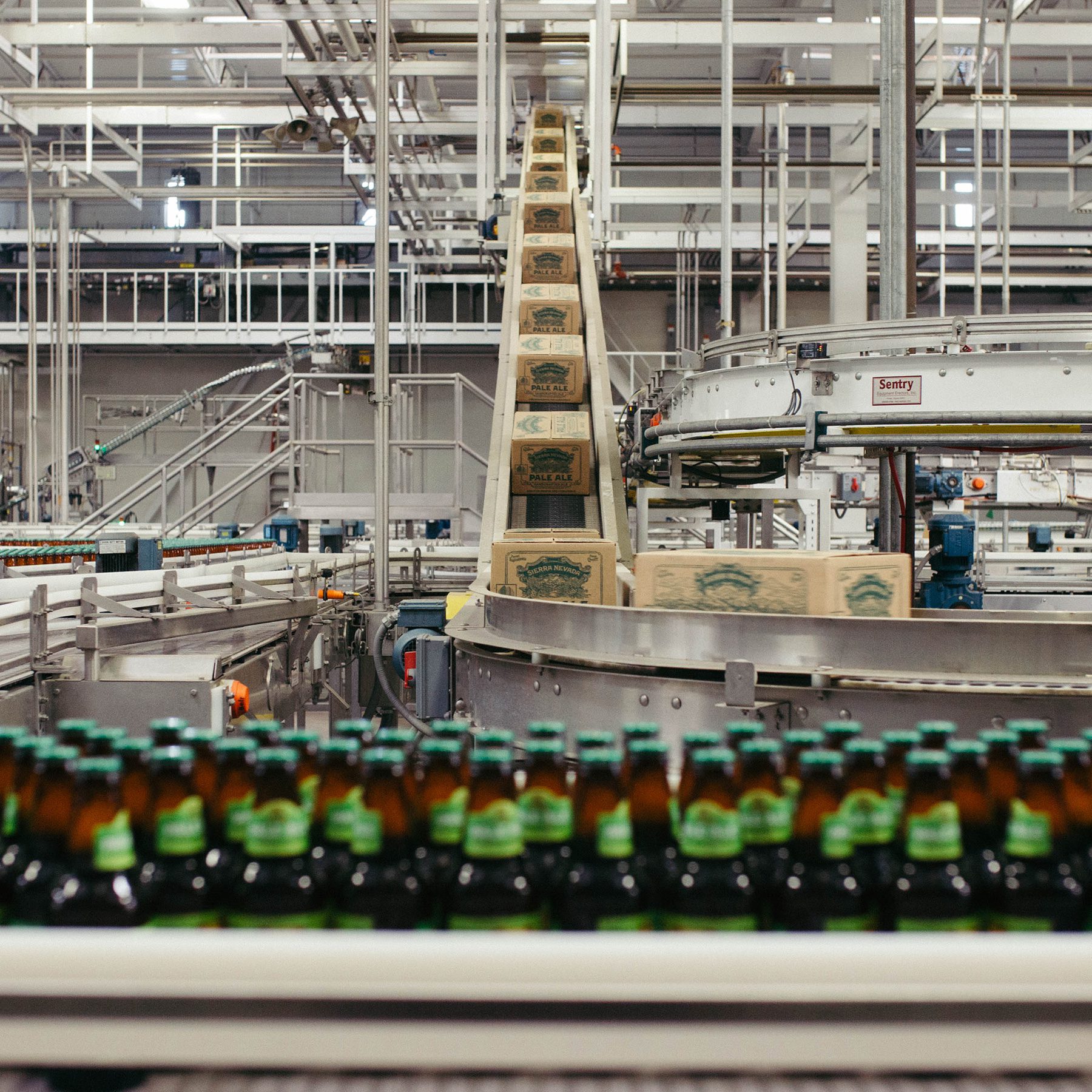 Bottles and boxes of Sierra Nevada Pale Ale on packaging line conveyer belts
