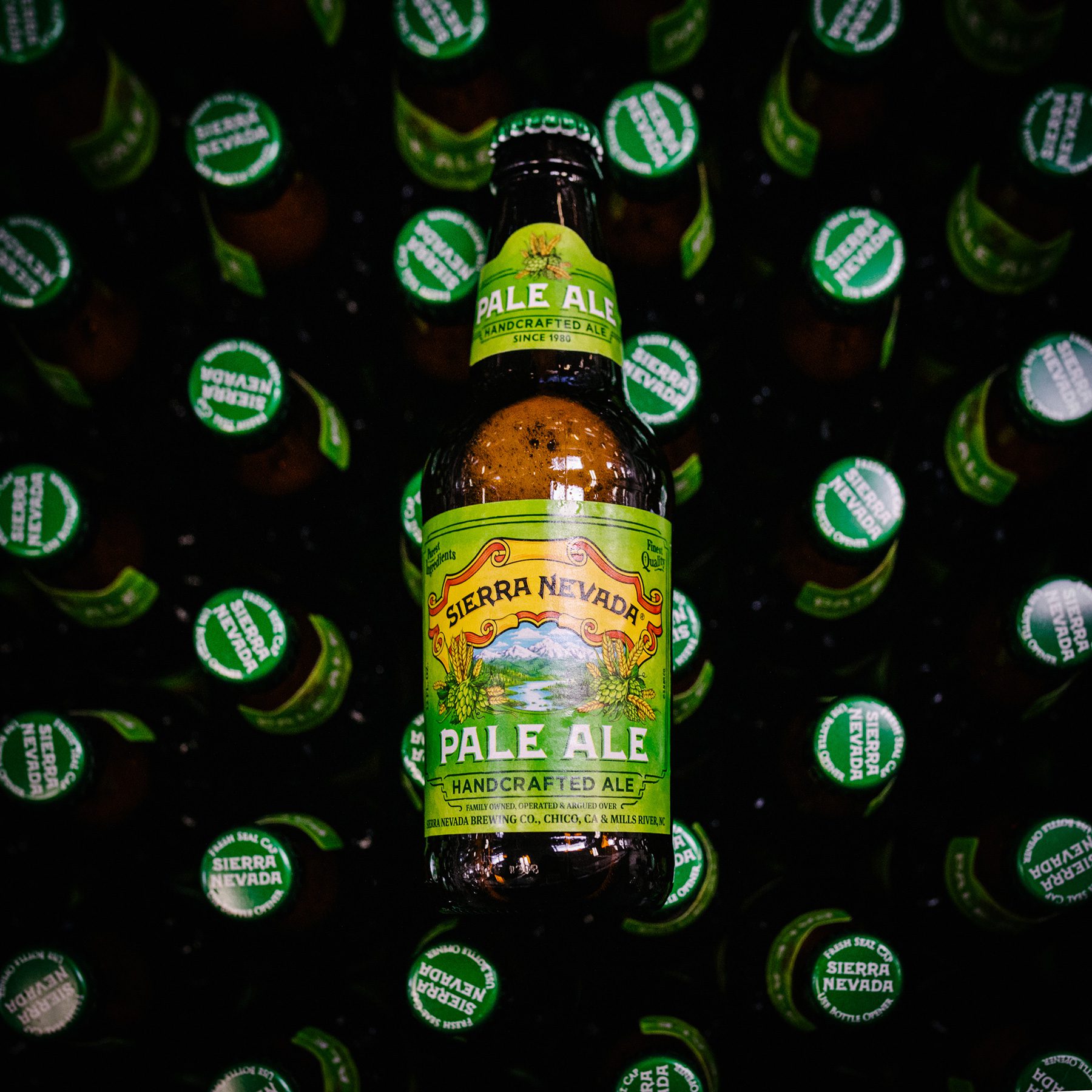 A bottle of Sierra Nevada Pale Ale crowdsurfing atop more beer bottles