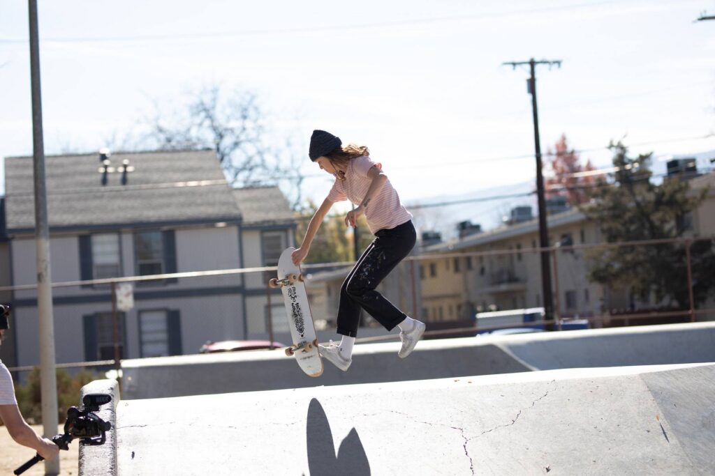 Artist Hannah Eddy in midair while skateboarding