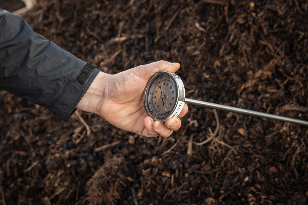 Industrial thermometer checking the temperature in a pile of compost