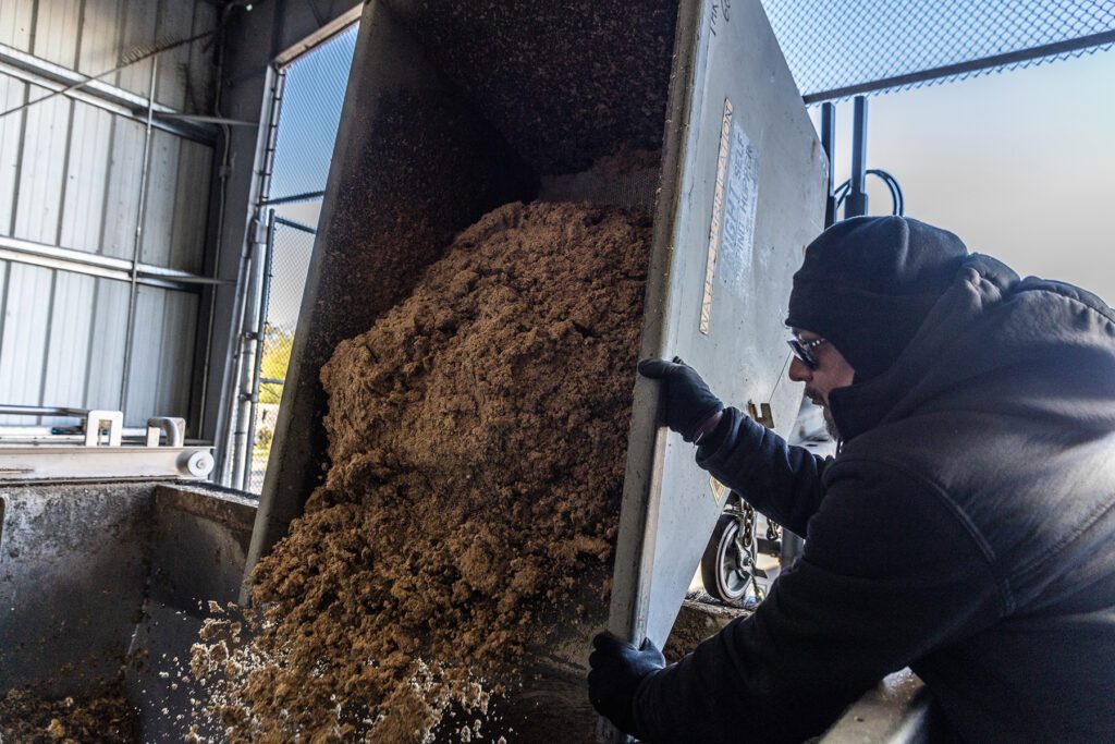 Sierra Nevada worker dumping spent brewing grains into the HotRot composting machine