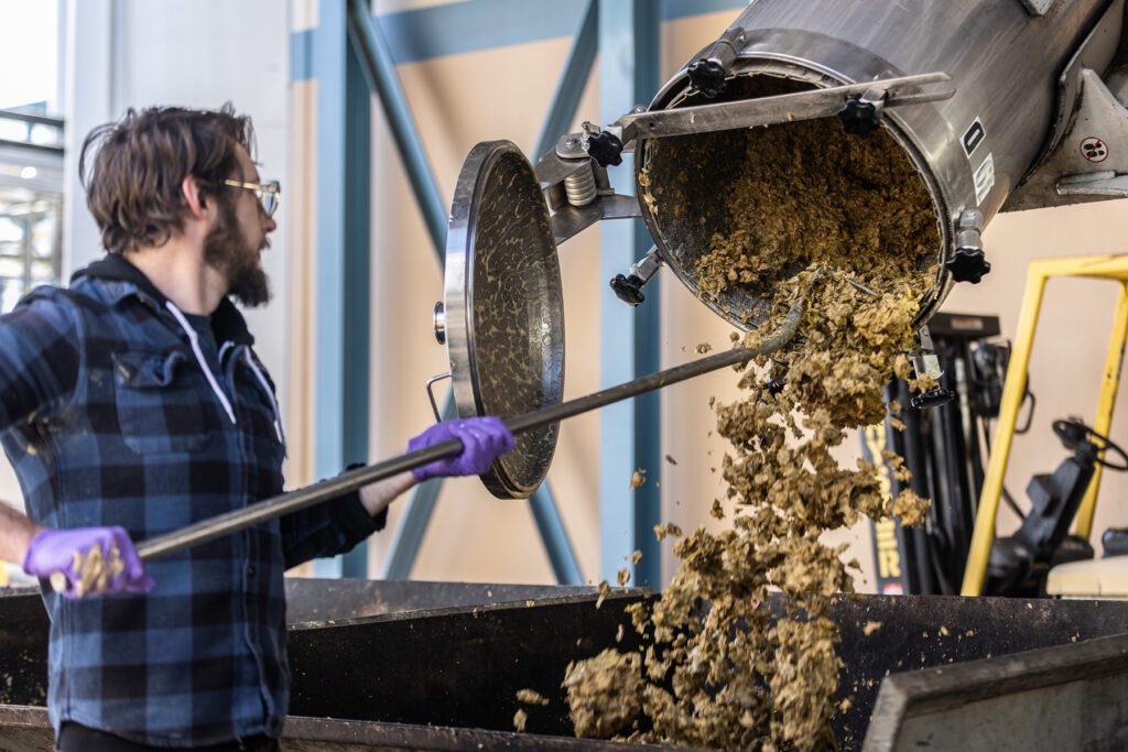 Sierra Nevada brewer emptying hops from a Hop Torpedo device
