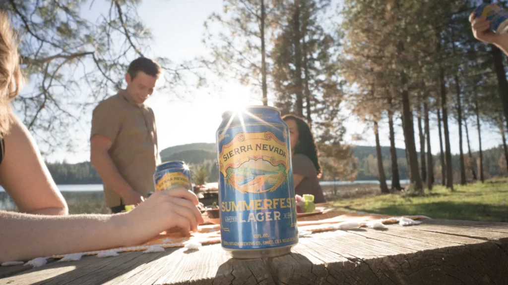 Sierra Nevada Summerfest Lager can on table outside with backdrop of trees and sunshine