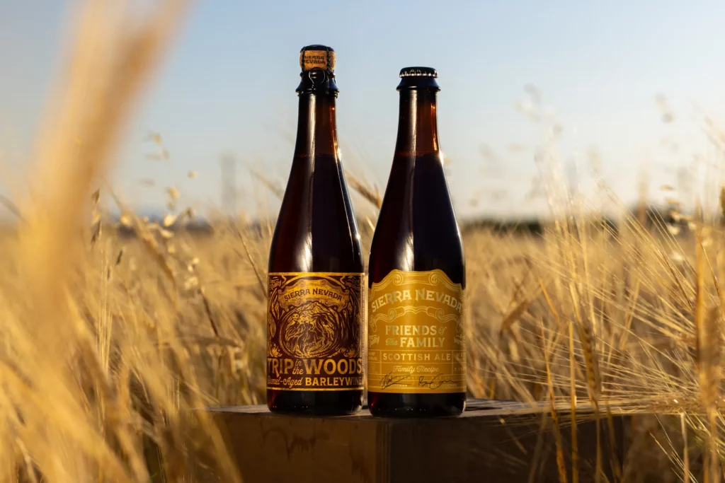 Friends of the Family beers in front of a field of barley
